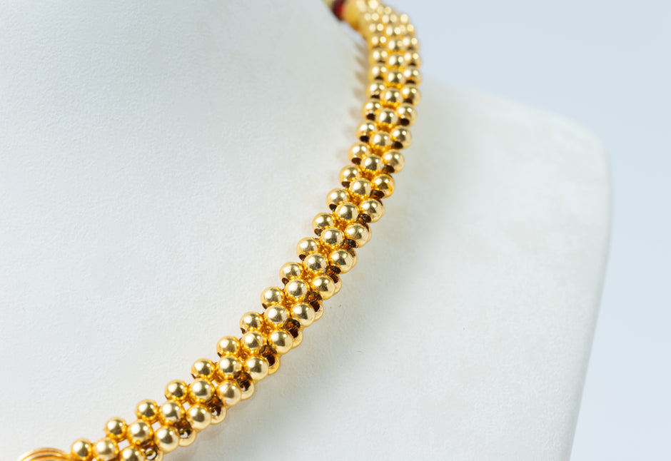 Traditional Gold-Tone Beaded Necklace with Green Floral Pendant